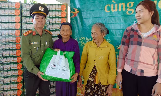 Đại diện lãnh đạo Công an huyện Đại Lộc trao quà cho bà con.