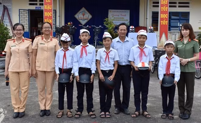 Tặng mũ bảo hiểm cho học sinh tham gia chương trình tuyên truyền an toàn giao thông.