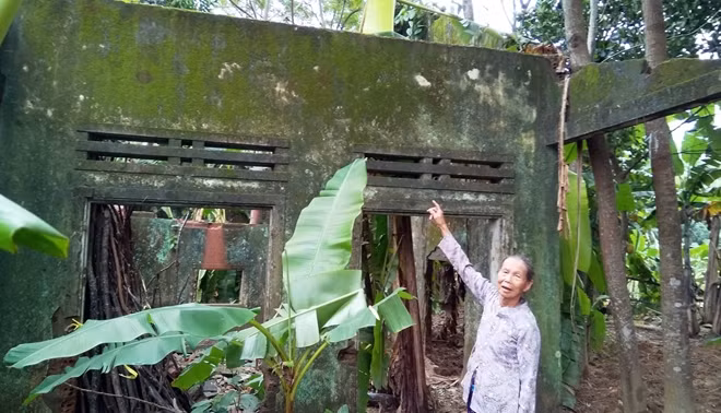 Bà Lợi bên căn nhà bỏ hoang của gia đình sau trận lũ lịch sử năm 1999.