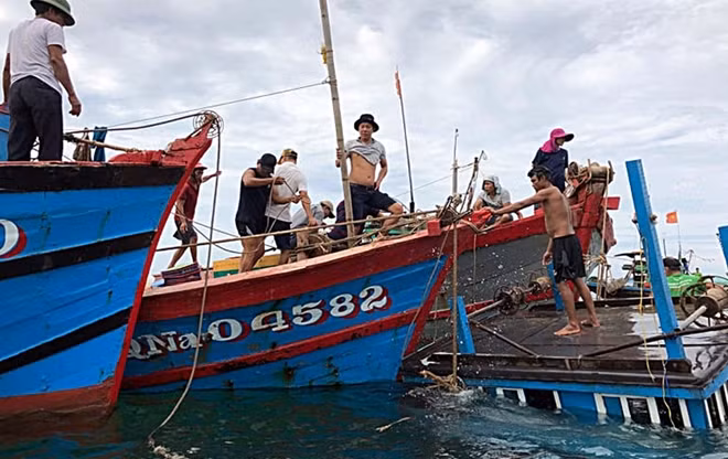 Ngư dân cùng chính quyền địa phương hỗ trợ trục vớt tàu cá bị chìm.