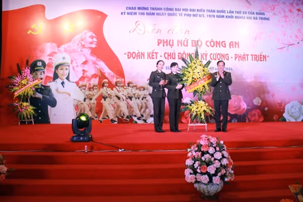 Thiếu tướng Đỗ Ngọc Cẩn tặng hoa chúc mừng đại diện Ban Thường vụ Hội phụ nữ Bộ Công an.