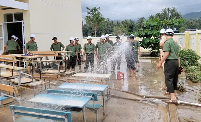 Thu dọn vệ sinh sân trường, lớp học và tẩy rửa bùn đất trên bàn ghế học sinh ở Trường tiểu học Xuân Phú, thị xã Sông Cầu
