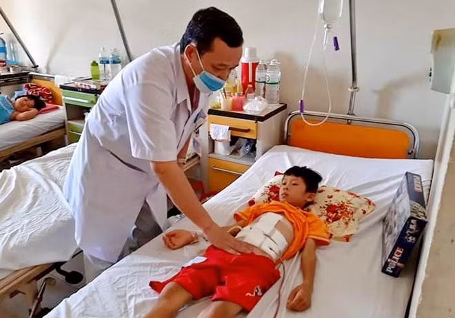 Bác sĩ Ngô Thế Lâm - Trưởng khoa ngoại tổng quát Bệnh viện đa khoa tỉnh Khánh Hòa kiểm tra sức khỏe bệnh nhi Võ Thanh T sau ca mổ. Ảnh : Bệnh viện Đa khoa Khánh Hòa