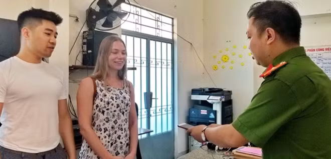 Bà Ekaterina nhận lại điện thoại từ tay điều tra viên. Ảnh: CATP Nha Trang