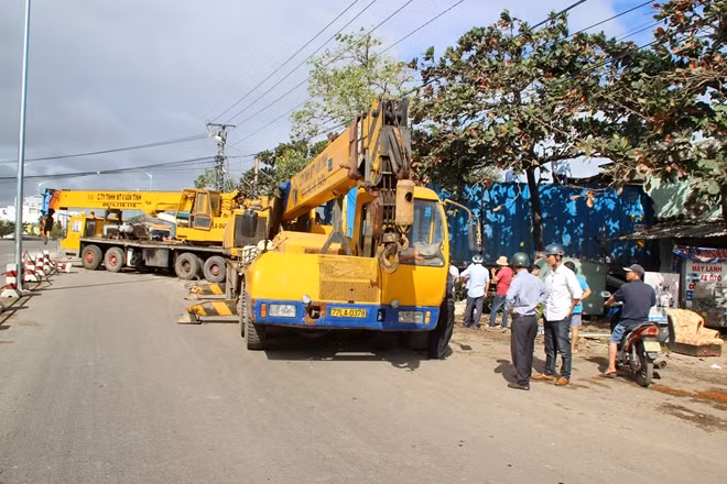 Lực lượng chức năng phải huy động hàng chục công nhân cùng 3 xe cơ giới chuyên dụng cẩu xe đầu kéo ra khỏi hiện trường. Ảnh: CTV
