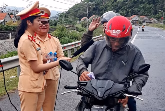 Cùng với việc tặng quà, nữ CSGT tranh thủ tìm hiểu kiến thức người dân một số quy định về nồng độ cồn, tốc độ xe máy để tuyên truyền vận động chấp hành pháp luật về giao thông