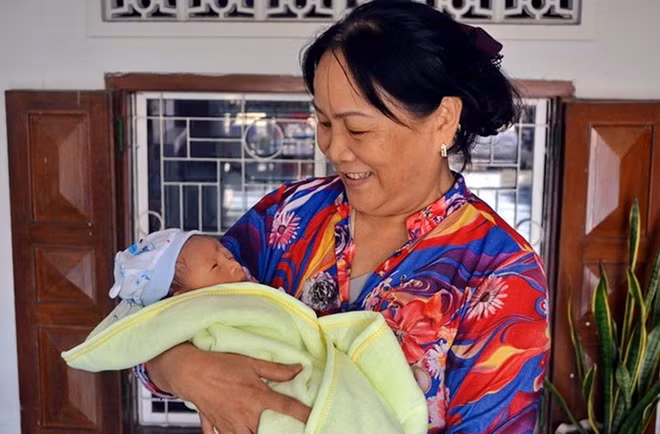 Bà Nguyễn Thị Nhân bế đứa trẻ sơ sinh bị bỏ rơi. Ảnh: Truy Phong