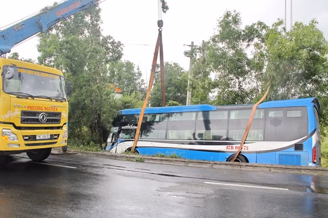 Cẩu kéo xe ô tô khách lâm nạn rời khỏi hiện trường.