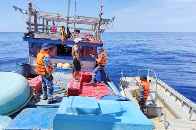 Cán bộ - chiến sĩ Tàu 522 đang kết nối hệ thống dây lai dắt tàu cá BĐ-95900 TS. Ảnh : BTL Vùng 4 Hải quân
