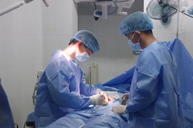 Ê kíp y- bác sĩ quân y đang thao tác chuyên môn y khoa trong ca mổ cấp cứu bệnh nhân Nguyễn Xiêm. Ảnh : Bệnh xá đảo Trường Sa
