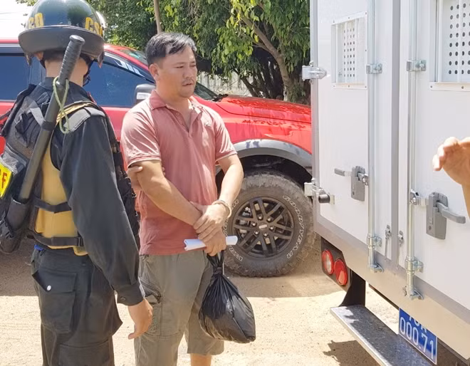 Dẫn giải bị can Trần Quang Hưng ra xe đặc chủng đưa về trại tạm giam. Ảnh : Hữu Toàn