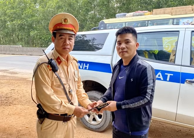 Trung tá Trần Chí Dũng trao trả lại tài sản đã nhặt được cho anh Đặng Quang Trung. Ảnh : Công an Bình Định