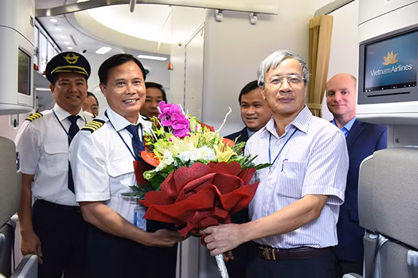 Phó Tổng Giám đốc Vietnam Airlines Nguyễn Ngọc Trọng (ngoài cùng bên phải) tặng hoa và chúc mừng cơ trưởng của chuyến bay.