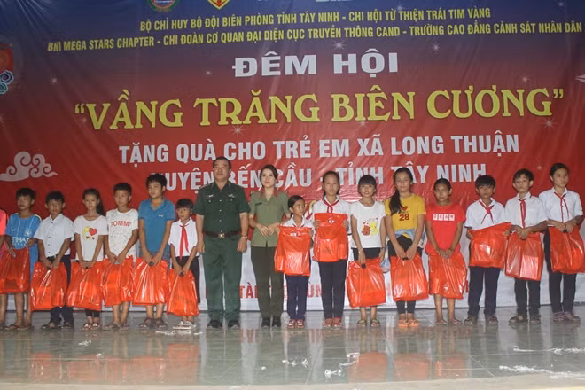 Đại diện Bộ đội biên phòng tỉnh Tây Ninh và đại diện Đoàn thanh niên Chi đoàn Cơ quan đại diện Cục truyền thông CAND trao quà cho các em