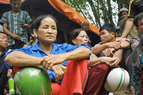 Dù rất đói và mệt nhưng bà Linh vẫn cố bám trụ hiện trường chờ tin tức của người thân.