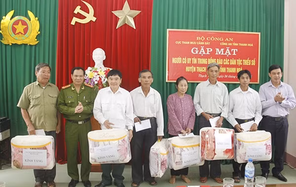 Lãnh đạo Cục Tham mưu Cảnh sát và lãnh đạo huyện ủy huyện Thạch Thành tặng quà cho những người có uy tín.
