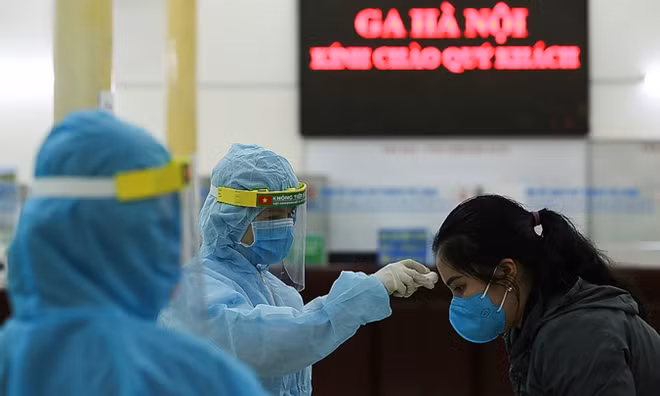 Đo nhiệt độ cho hành khách tại Ga Hà Nội. Ảnh: Reuters.