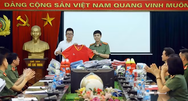 Thiếu tá Nguyễn Ngọc Hưng thay mặt Đội bóng đá Báo CAND tiếp nhận quần áo, bóng từ nhà tài trợ.