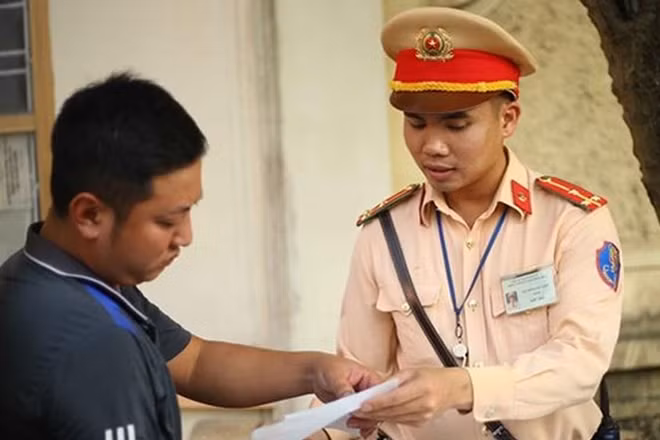 Thượng úy Nguyễn Văn Tiến tuyên truyền, nhắc nhở người dân thực hiện đảm bảo an toàn giao thông.