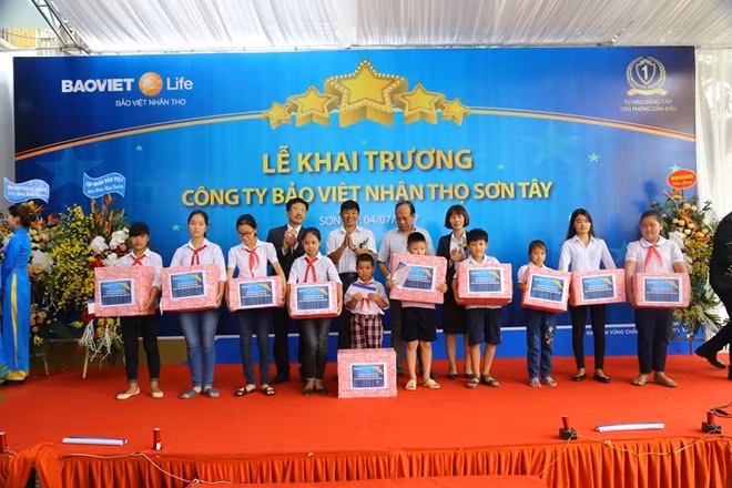 Đại diện Công ty Bảo Việt Nhân thọ Sơn Tây trao tặng quà cho các em nhỏ địa phương