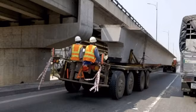 Xe chở dầm cầu lưu thông qua cầu Kinh Xáng trong dòng người đông đúc và hàng loạt phương tiện các loại vào lúc 11h35 ngày 19-1 (25 tháng Chạp).