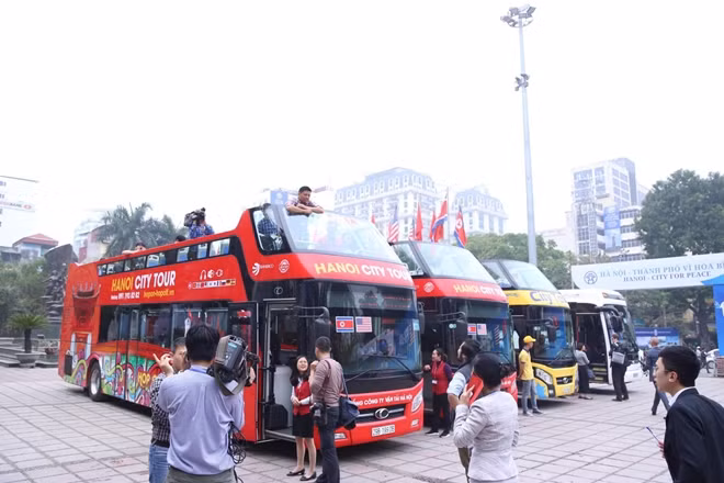 Xe bus hai tầng chở phóng viên di chuyển đến nơi họp báo.