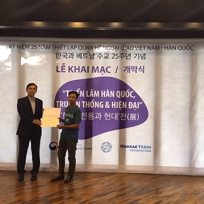 Giám đốc Trung tâm văn hóa Hàn Quốc tại Việt Nam Lee Dae Joong trao giải nhất cho họa sĩ Phạm Thuấn.