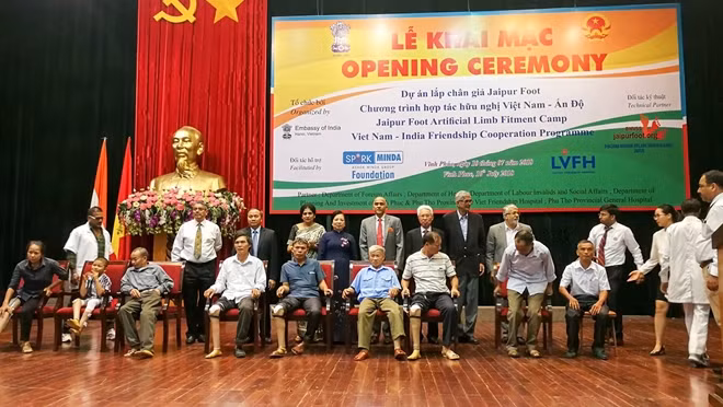 Phu nhân Nguyễn Thị Hiền cùng Đại sứ Harish và các đại biểu chụp ảnh lưu niệm với những người khuyết tật được lắp chân giả.