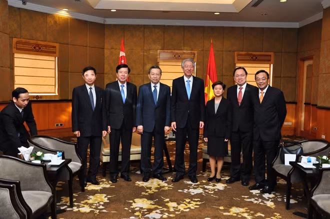 Bộ trưởng Tô Lâm và Phó Thủ tướng, Bộ trưởng Bộ điều phối an ninh quốc gia Singapore Tiêu Chí Hiền cùng các thành viên trong đoàn chụp ảnh lưu niệm.