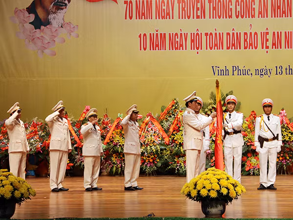 Bộ trưởng Trần Đại Quang gắn Bảo vệ Tổ quốc hạng Ba lên Cờ truyền thống Công an tỉnh Vĩnh Phúc.