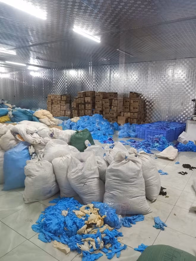 Găng tay nhăn nhúm được vứt lả tả dưới nền gạch trong kho hàng