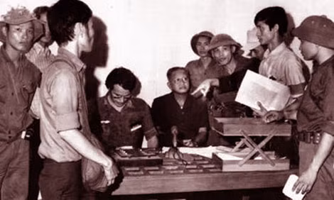Tổng thống Việt Nam Cộng hòa Dương Văn Minh chuẩn bị tuyên bố đầu hàng (ông Nguyễn Hữu Thái đứng thứ hai bên phải, tay cầm tập giấy). Ảnh: Kỳ Nhân.