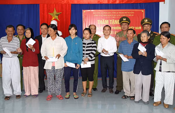 Đại diện Báo CAND, Công an TP Đà Nẵng cùng ông Thân Đức Khánh - Giám đốc Hatoco tặng quà Tết cho bà con Làng Vân tái định cư.
