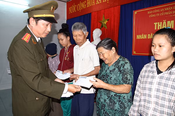 Đại diện Báo CAND, Công an TP Đà Nẵng cùng ông Thân Đức Khánh - Giám đốc Hatoco tặng quà Tết cho bà con Làng Vân tái định cư.
