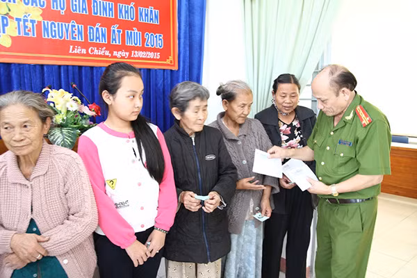 Đại diện Báo CAND, Công an TP Đà Nẵng cùng ông Thân Đức Khánh - Giám đốc Hatoco tặng quà Tết cho bà con Làng Vân tái định cư.