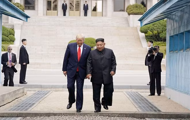 Tổng thống Donald Trump và Chủ tịch Kim Jong-un bước qua gờ bê tông ngăn cách hai miền Triều Tiên tại Panmunjom. Ảnh: Reuters