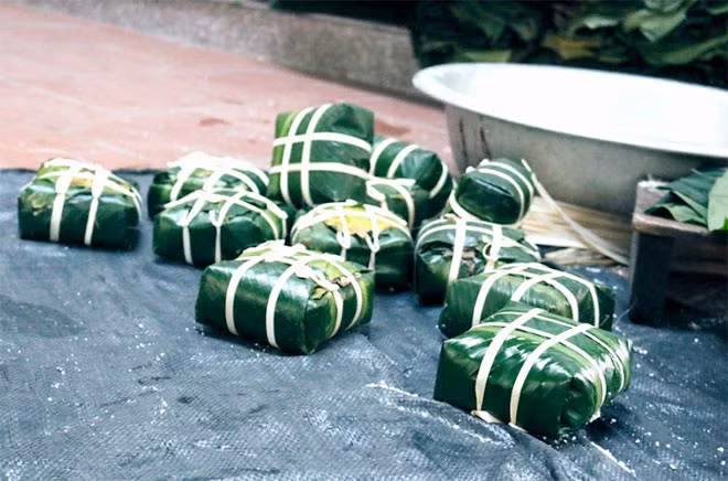 Những chiếc bánh phủ màu xanh ngắt của lá dong, không cần khuôn mà nhìn cái nào cái nấy đều rất vuông vức