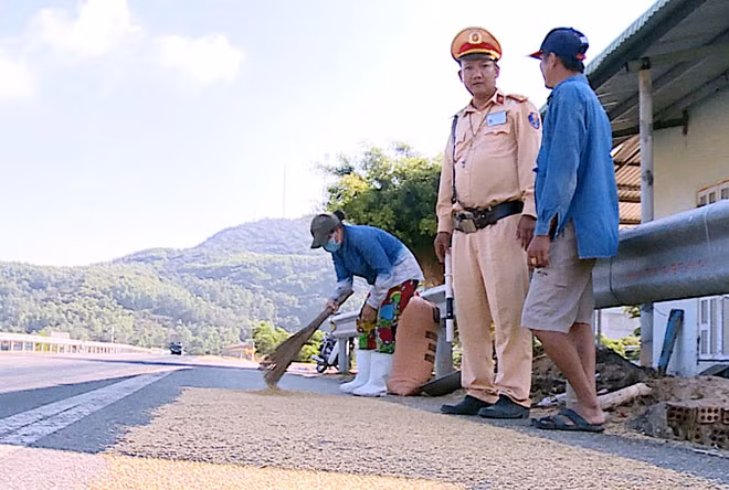 CSGT Công an tỉnh Quảng Ngãi xử lý, buộc người dân thu gom lúa phơi trên quốc lộ 1A.