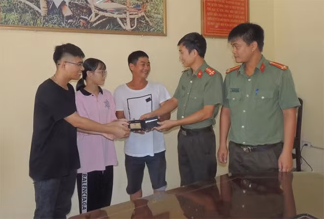 Công an huyện Bình Lục và 2 em Hoàng, Dung trả lại tài sản cho người bị mất.