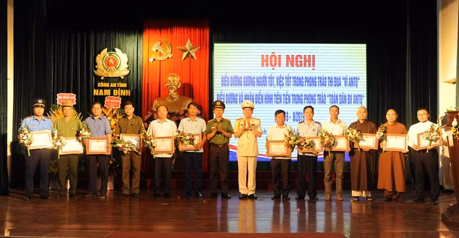 Đại tá Phạm Văn Long, Giám đốc Công an tỉnh và đại diện Cục Công tác phong trào trao Giấy khen tặng các cá nhân tiêu biểu.