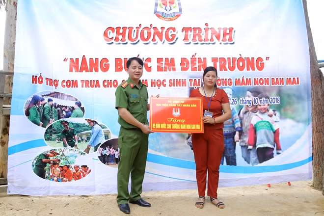 Thiếu tá Phan Văn Thịnh, Phó trưởng phòng phụ trách phòng Công tác Đảng, công tác chính trị và công tác quần chúng trao 5 phần quà là bồn nước cho Trường Mầm non Ban Mai.