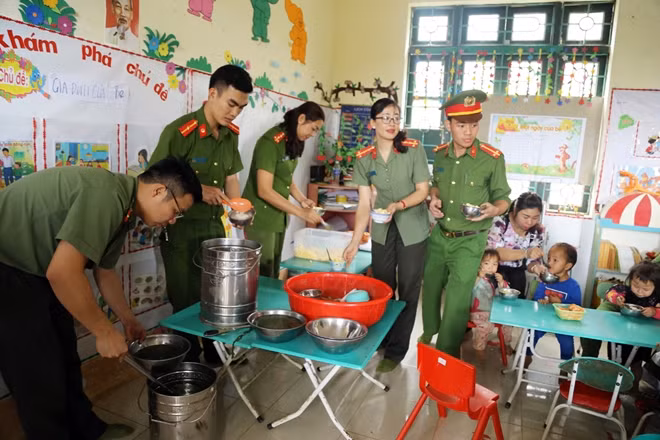 Các thành viên trong đoàn tình nguyện chuẩn bị cơm trưa và bón cơm cho các bé mầm non.