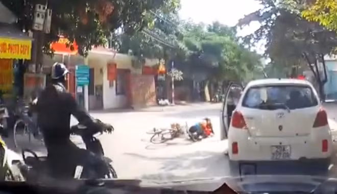 Chủ xe mở cửa thiếu ý thức đã khiến một cháu bé đi xe đạp bị ngã lăn ra đường.