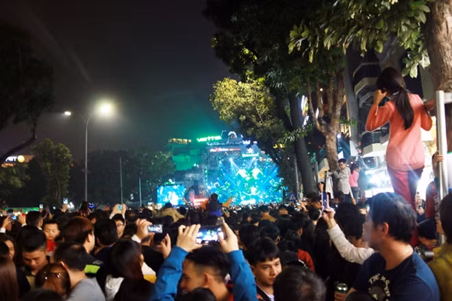 Để có chỗ view tốt, nhiều người trèo cả lên các khung được dựng để bảo vệ cây.