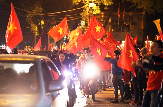Hầu như mỗi người đều cầm trên tay hoặc khoác trên vai một lá cờ đỏ sao vàng.