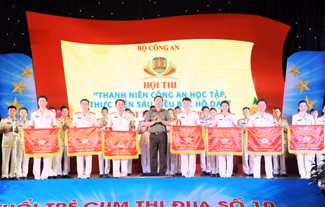 Thiếu tướng Bùi Minh Giám trao Cờ lưu niệm tặng các đội tuyển tham gia Hội thi.