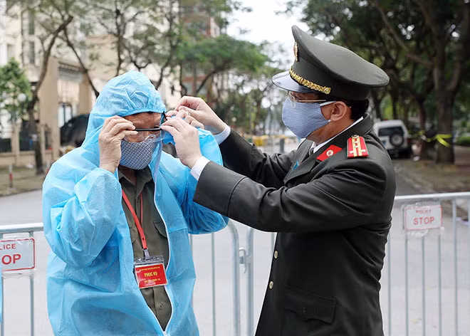 Đại tá Phạm Quang Khải trực tiếp hướng dẫn cách sử dụng bộ đồ bảo hộ y tế cho một cán bộ tham gia phòng, chống dịch COVID-19.