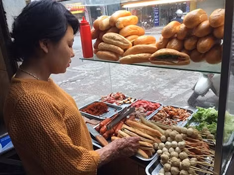 Giang phụ giúp bán bánh mì cho bác.