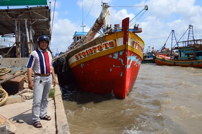 Ông Trần Huy Hoàng, bên chiếc tàu cá đã đưa 7 ngư dân bị nạn vào bờ an toàn.