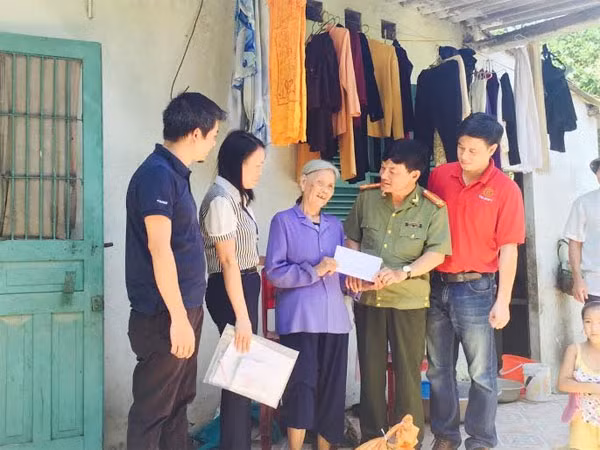 Đoàn công tác tặng quà bà Vũ Thị Vui, trú tại phường Quang Hanh. Hôm xảy ra lũ lụt, bà phải trèo lên cây khế để thoát thân.